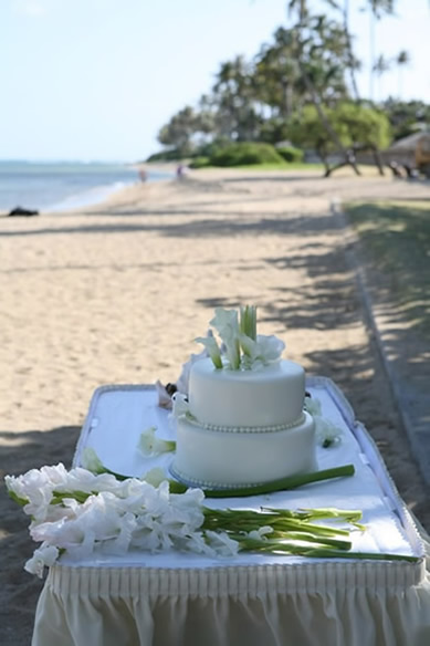all white wedding cake on the table over looking diamond head beach
